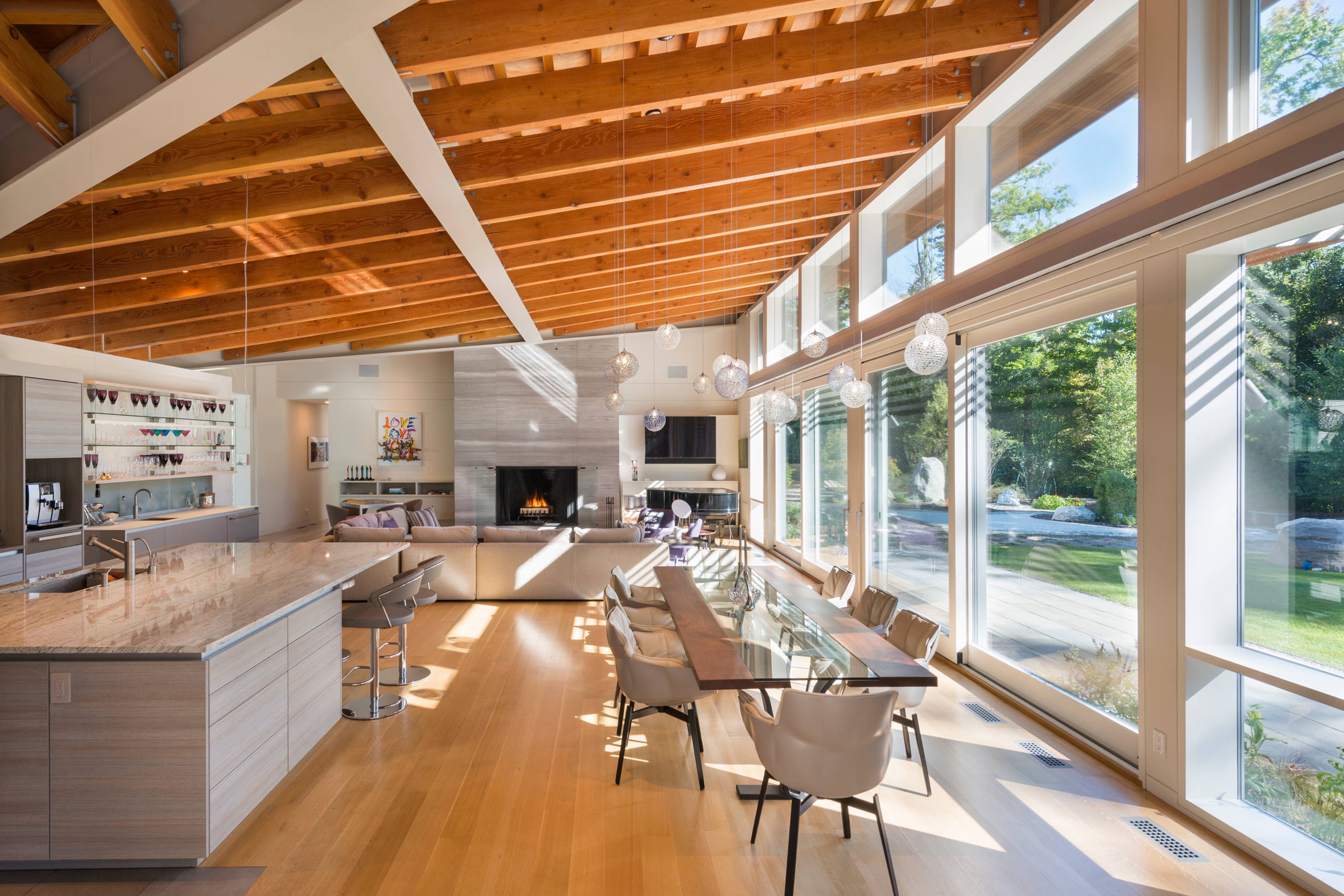 a SENTIENT contemporary designed Colorado table in maple with custom glass inset and blackened steel v shape leg detail view 