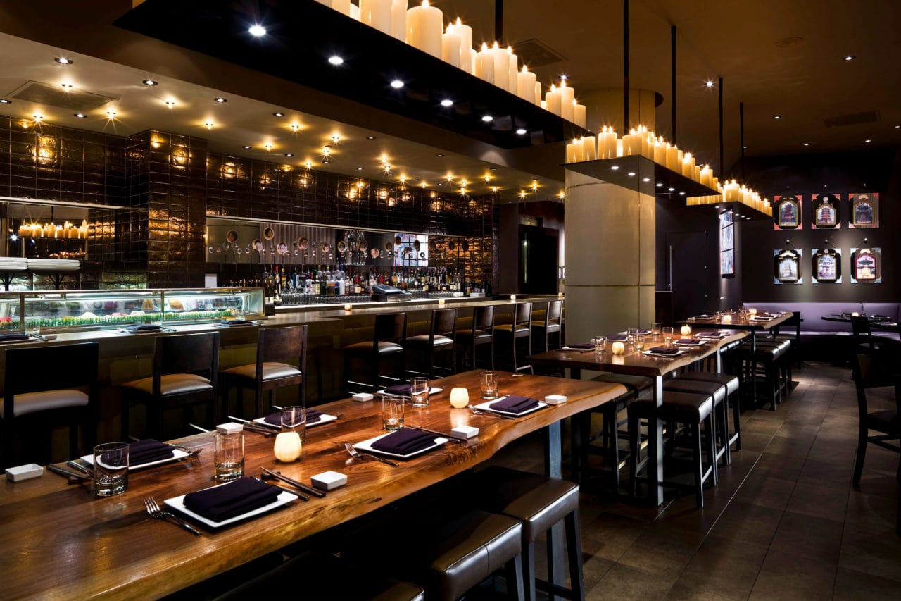 several luxury SENTIENT contemporary designed walnut live edge custom tables in zentan restaurant Kimpton Donovan hotel