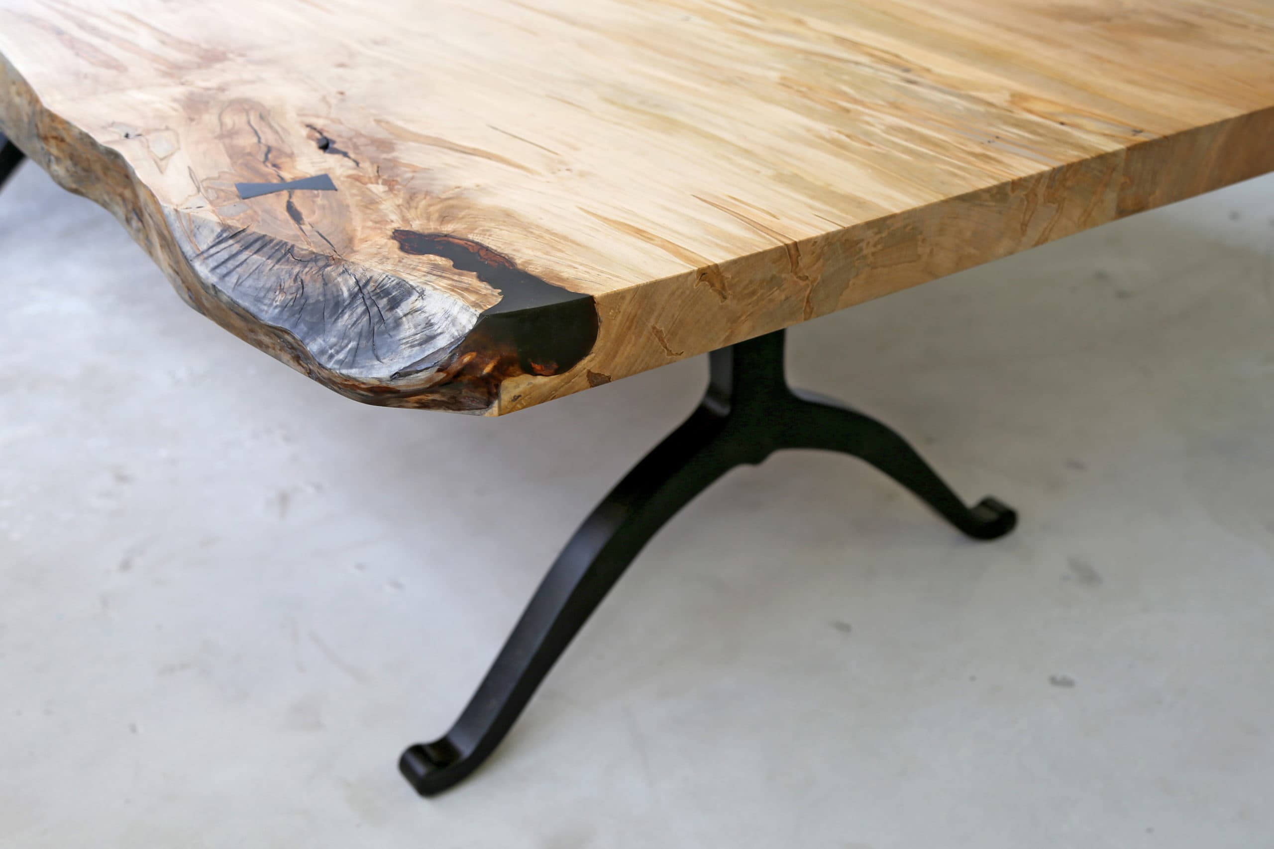 Live edge table maintenance - corner detail of a SENTIENT contemporary designed maple wood live edge custom table with black luxury wishbone legs]