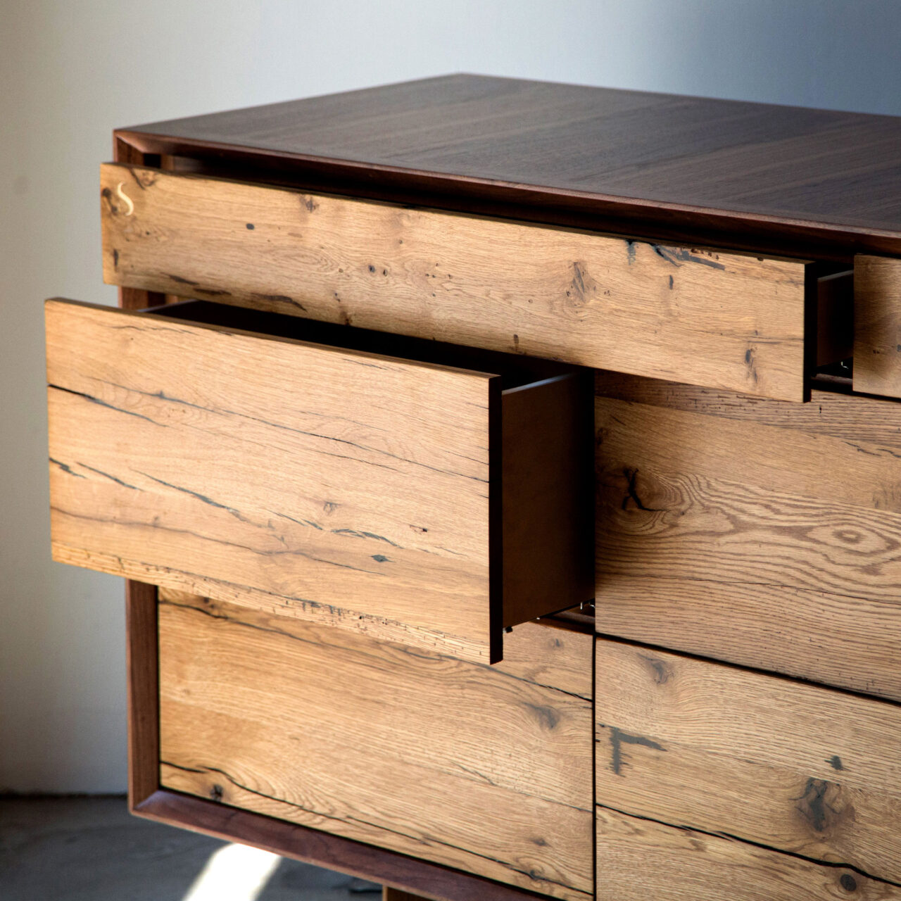 The SENTIENT luxury NewOld dresser, combining classic wood textures with a modern dark frame, displayed in a well-lit room with a white wall.