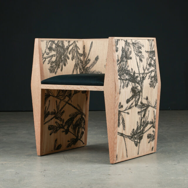 A modern artistic chair designed by SENTIENT Furniture in collaboration with Riccardo Vecchio, featuring intricate botanical artwork on wood panels and a sleek black cushion seat.