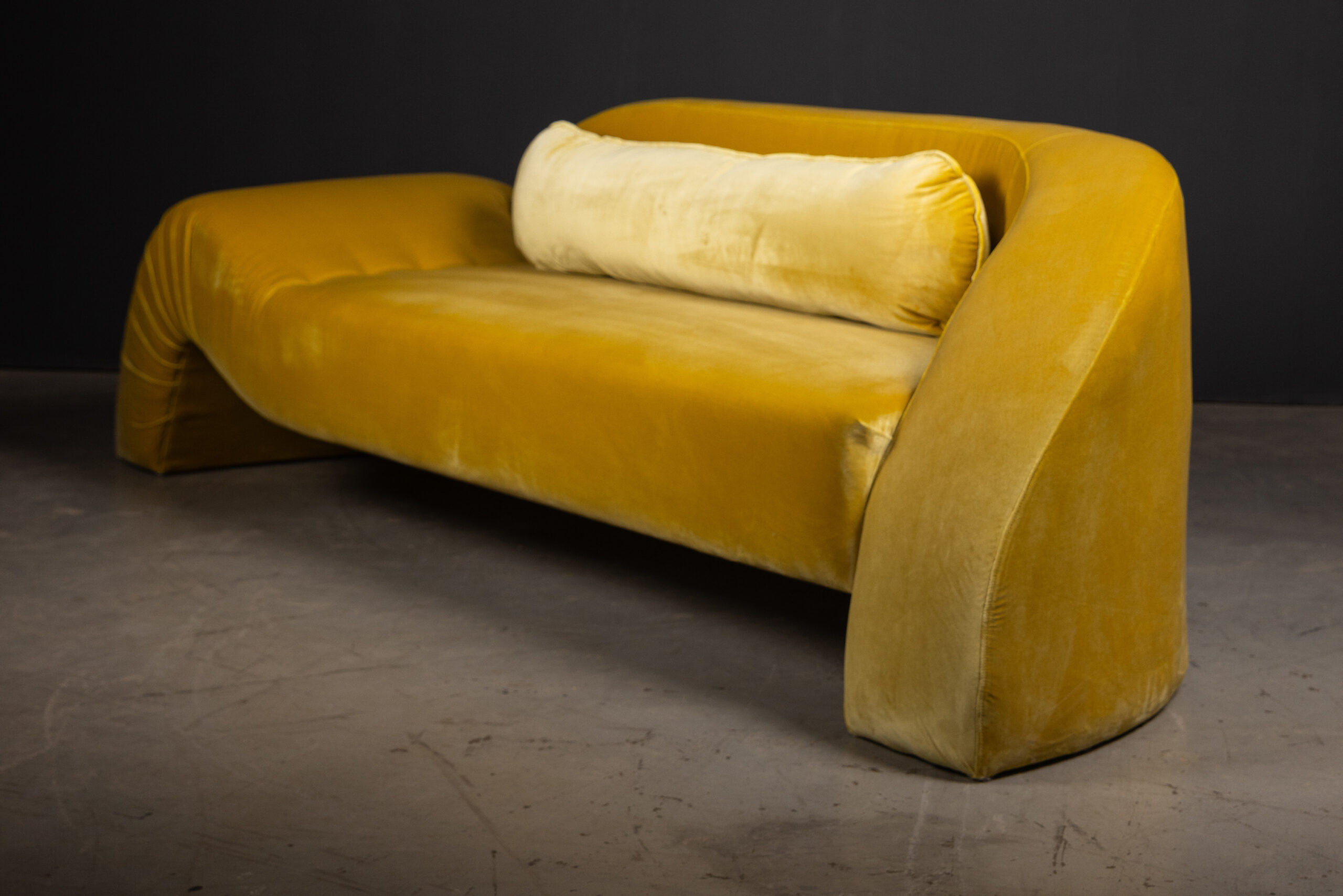 Sentient Aeon Sofa in Yellow Velvet (Curve Details) A close-up of the curved armrest of the Sentient Aeon Sofa in yellow velvet, highlighting its organic design and plush texture.