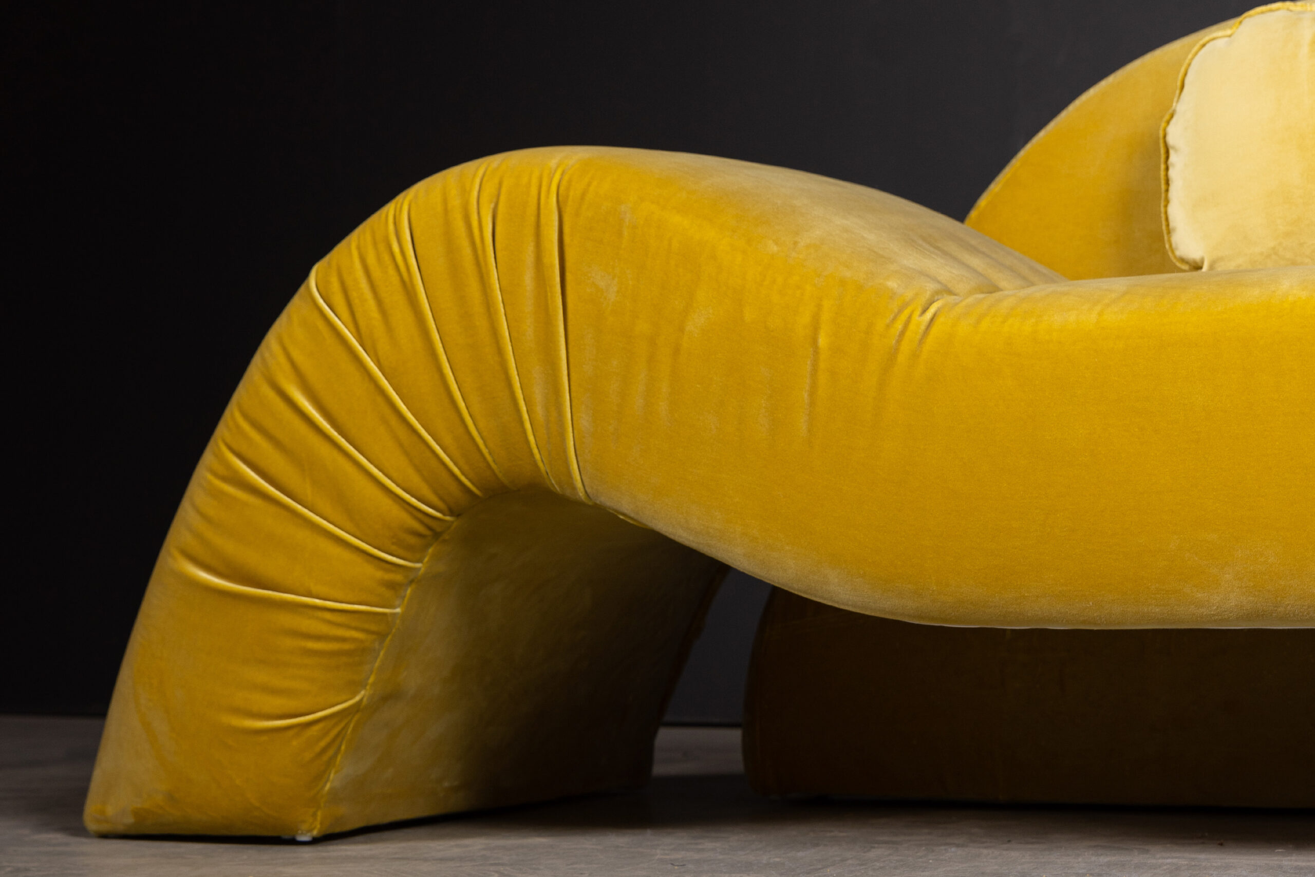 Sentient Aeon Sofa in Yellow Velvet (Front View Details) A close-up view of the Sentient Aeon Sofa in rich yellow velvet, showcasing its unique curves and plush, inviting design for modern living spaces.
