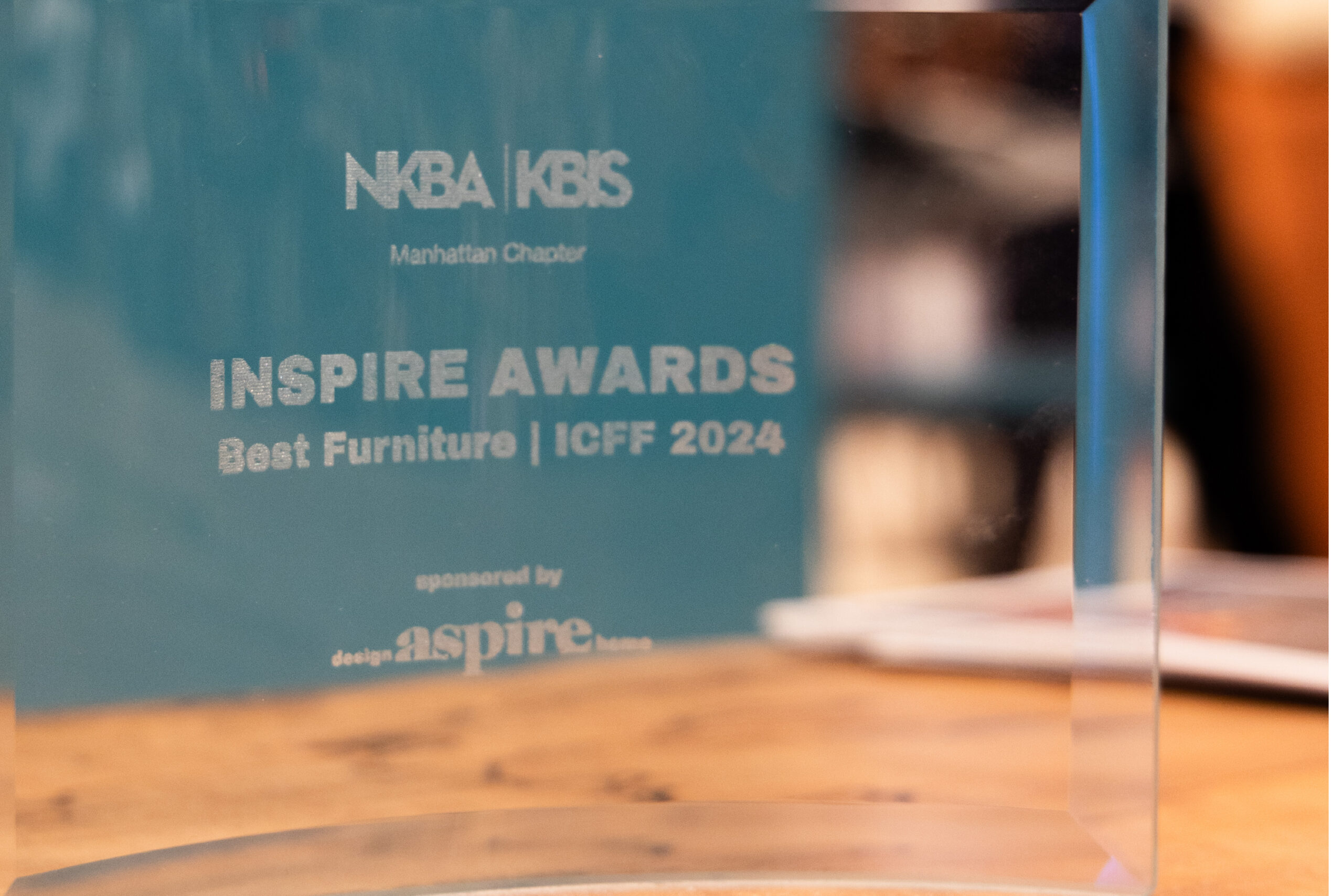 Sentient ICFF 2024 Best Furniture Award The ICFF 2024 Best Furniture Award trophy presented to Sentient Furniture, displayed on a wooden surface, celebrating design excellence.