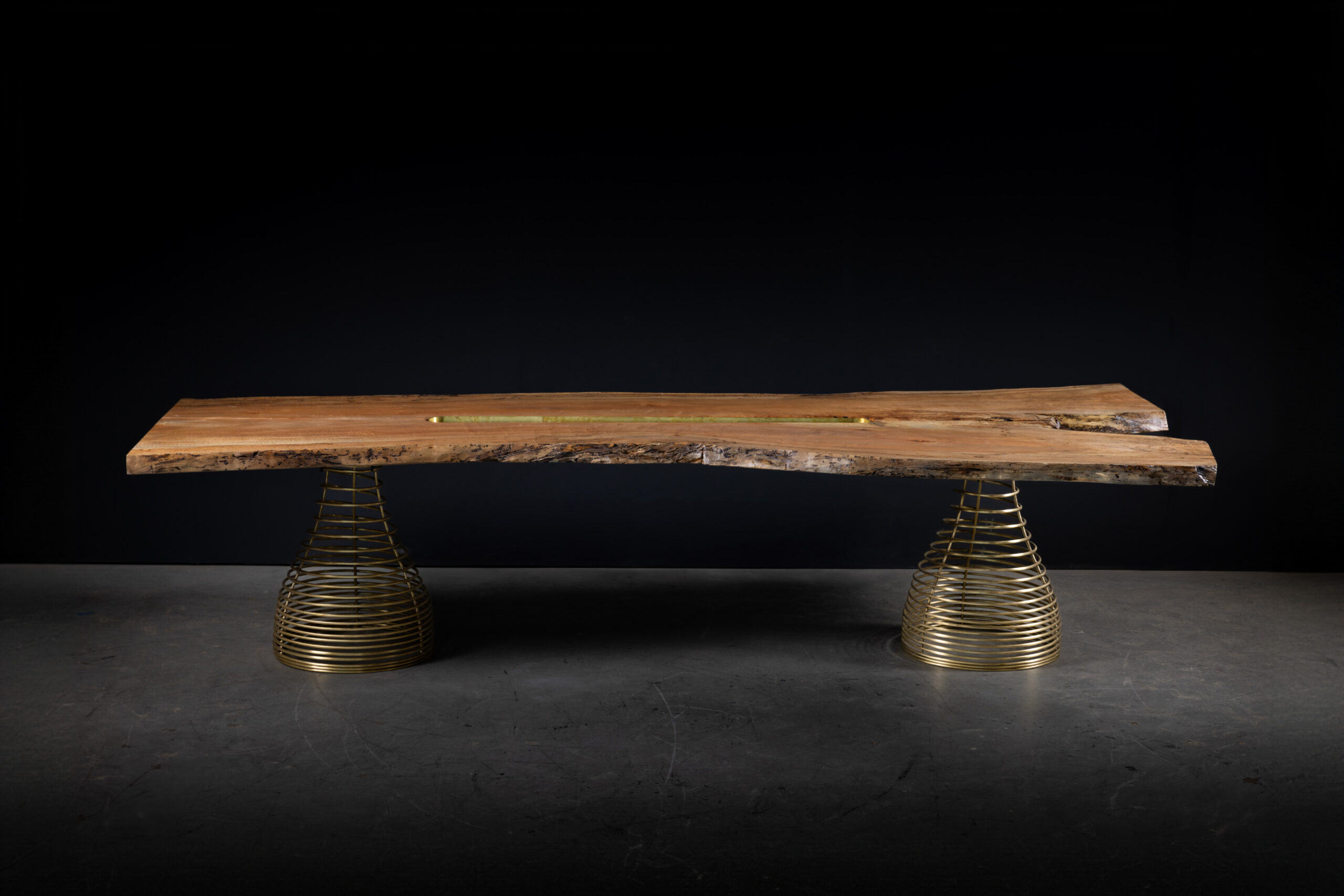 SENTIENT Rivulet Table in Live Edge Splatted Maple Side View A side view of the SENTIENT Rivulet Table, displaying the live edge splatted maple tabletop resting on modern brass spring legs.