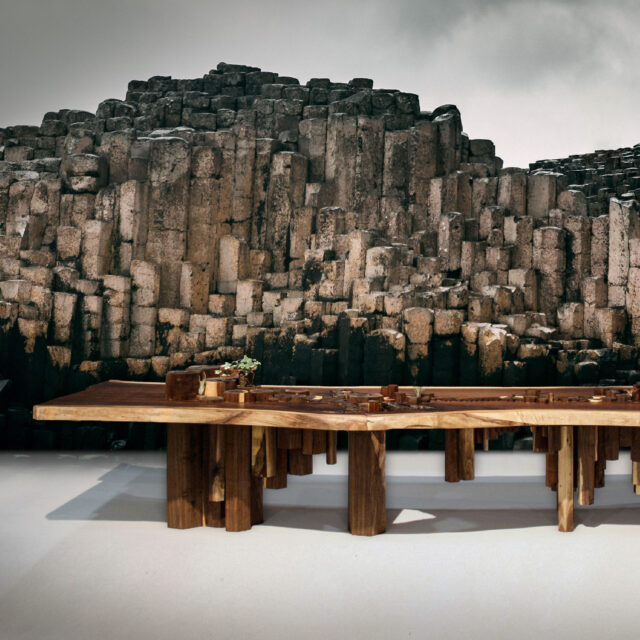 The SENTIENT Causeway Table crafted in walnut wood, inspired by the geometric formations of the Giant’s Causeway. The design features a stunning natural top with sculptural base elements, blending art and functionality.