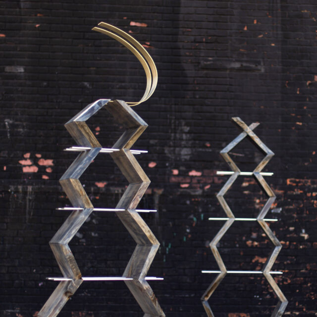 The SENTIENT Friends Bookcase featuring a sculptural modular design with geometric shapes and integrated brass and acrylic accents. A bold and artistic statement piece for modern interiors.