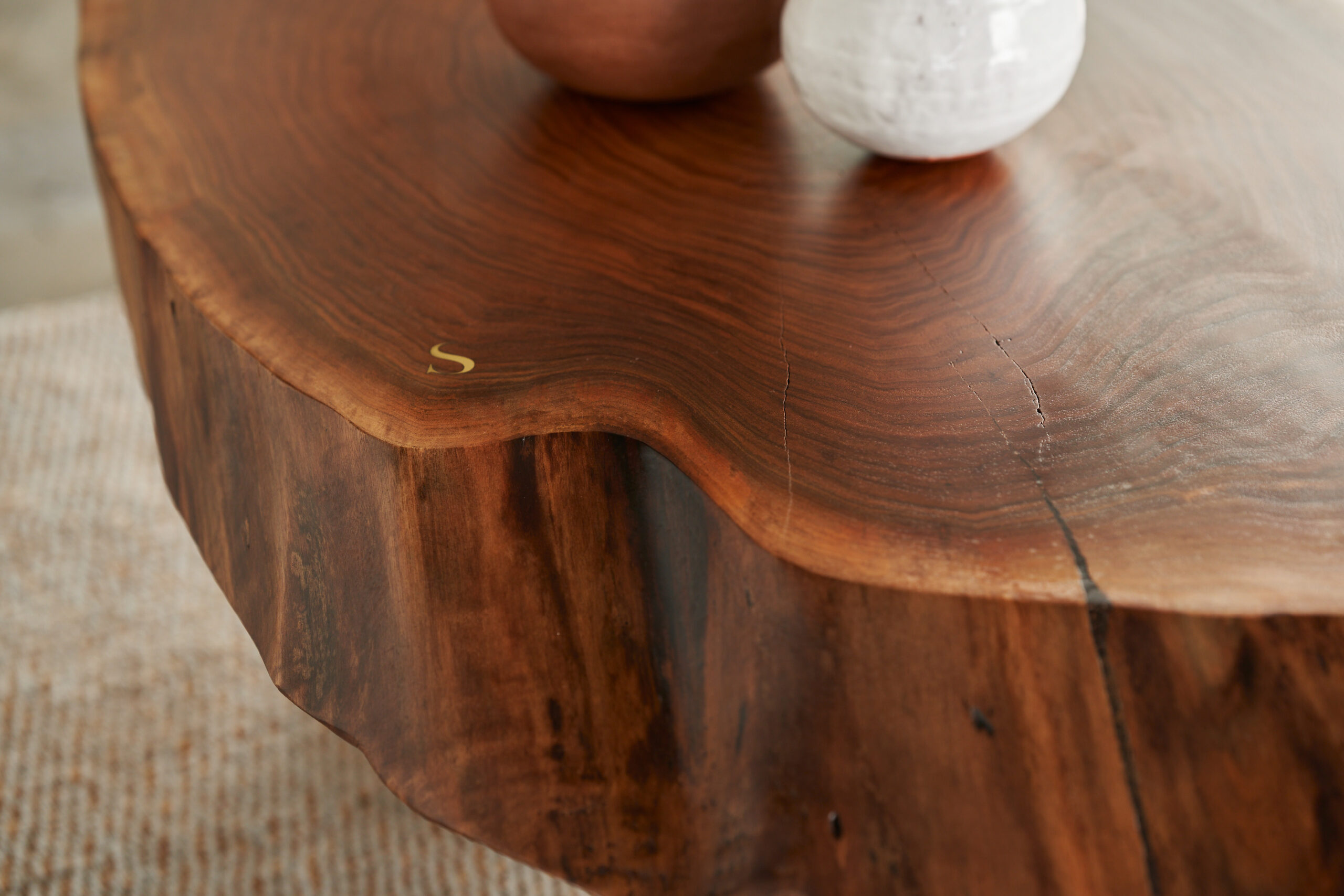Detailed View of SENTIENT's Sylvan Live-Edge Coffee Table Close-up view of SENTIENT's Sylvan live-edge coffee table showing the rich texture of walnut wood and refined edges, perfect for modern decor.