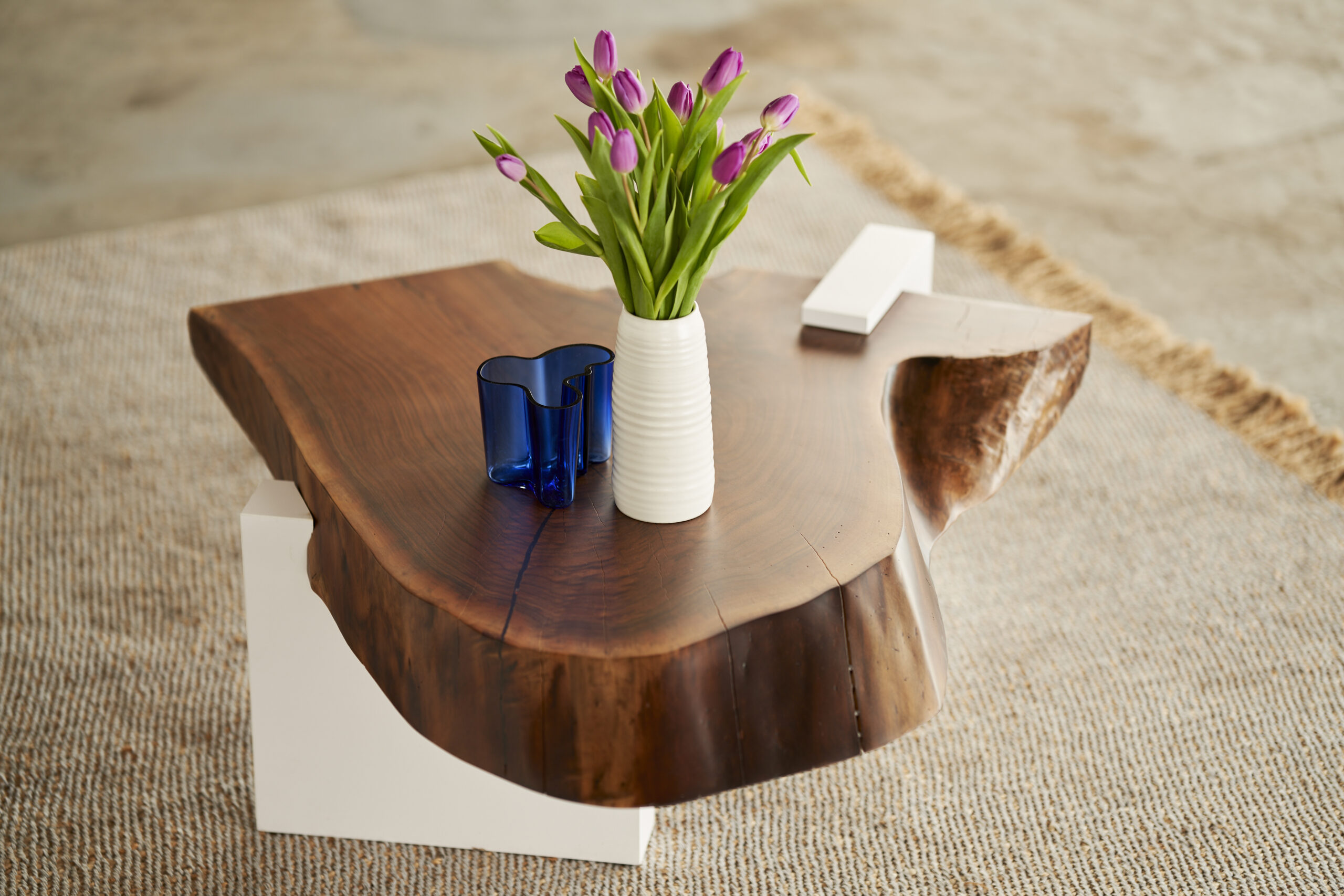 SENTIENT-Sylvan-Live-Edge-Coffee-Table-in-black-walnut Close-up of the SENTIENT logo inlay on a live-edge black walnut coffee table, highlighting detailed craftsmanship and elegant design.