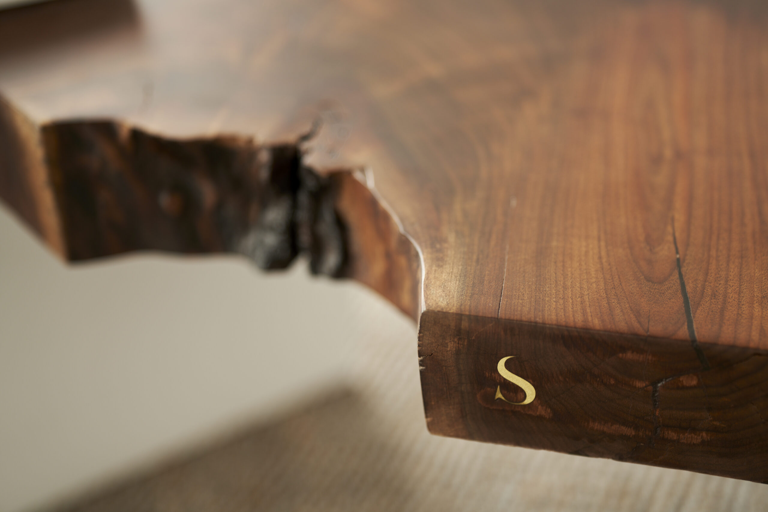 SENTIENT Sylvan Live Edge Coffee Table - Logo Inlay Detailed view of the SENTIENT logo inlay on the Sylvan Live Edge Coffee Table, showcasing fine craftsmanship.