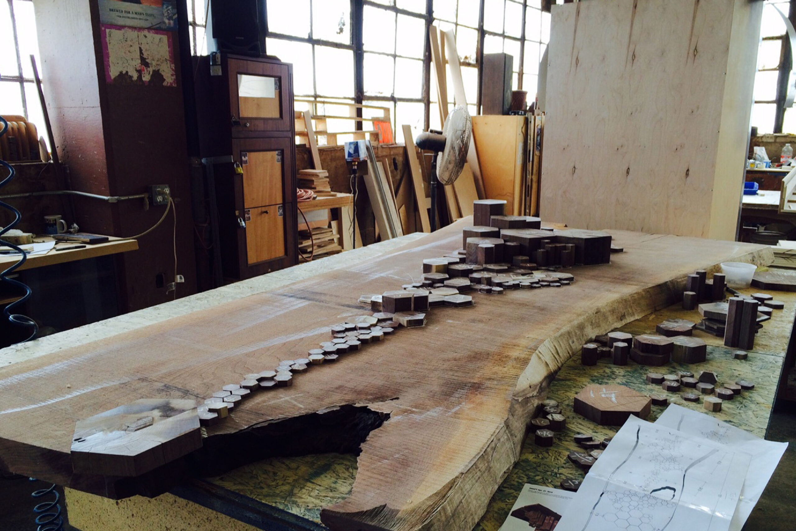 Making of SENTIENT Causeway Table A behind-the-scenes look at the crafting process of the SENTIENT Causeway Table, with detailed wooden segments arranged on a live-edge tabletop, inspired by Giant’s Causeway.