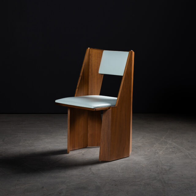 The SENTIENT Symphony Chair featuring a sleek walnut frame and light blue leather upholstery. The angular design and luxurious materials combine modern aesthetics with comfort.