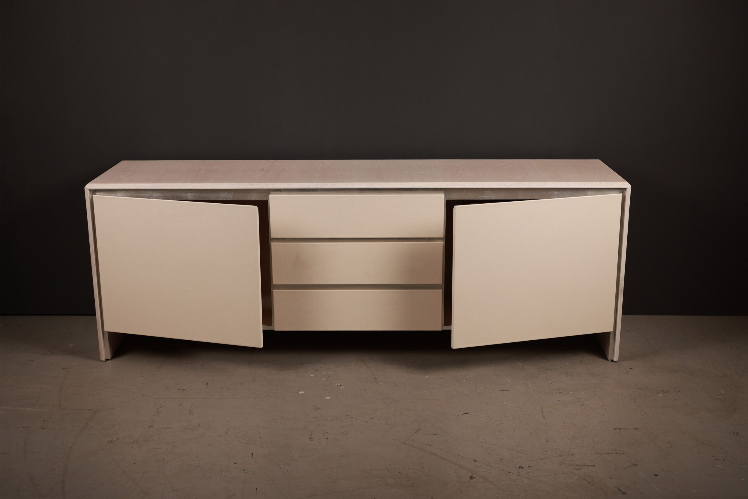 Prelude Credenza With Leather Front And Bleached Oak Body With Ope Prelude Credenza With Leather Front And Bleached Oak Body With Open Doors. High-quality image showcasing the design and details by SENTIENT Furniture.