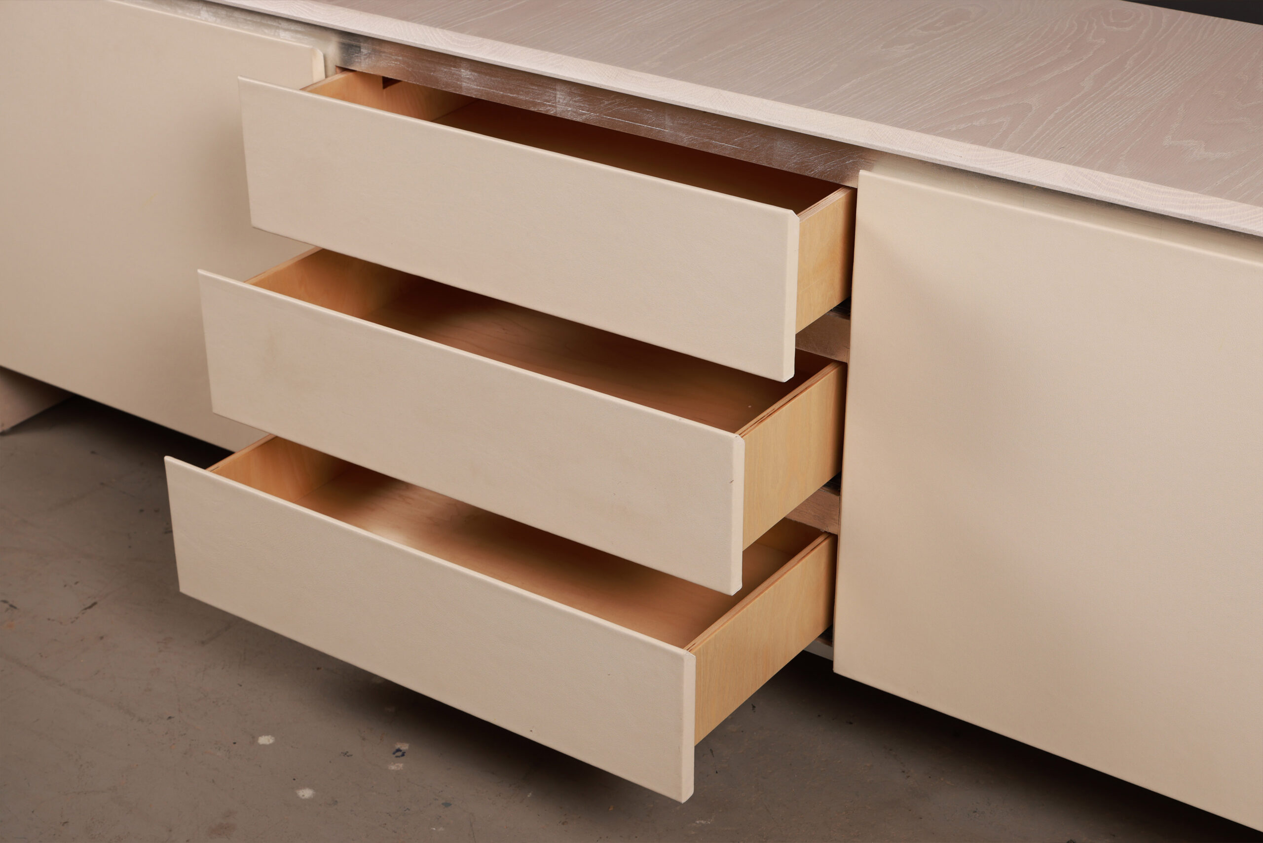 Prelude Credenza With Leather Front And Bleached Oak Body With Open Prelude Credenza With Leather Front And Bleached Oak Body With Open Drawers. High-quality image showcasing the design and details by SENTIENT Furniture.